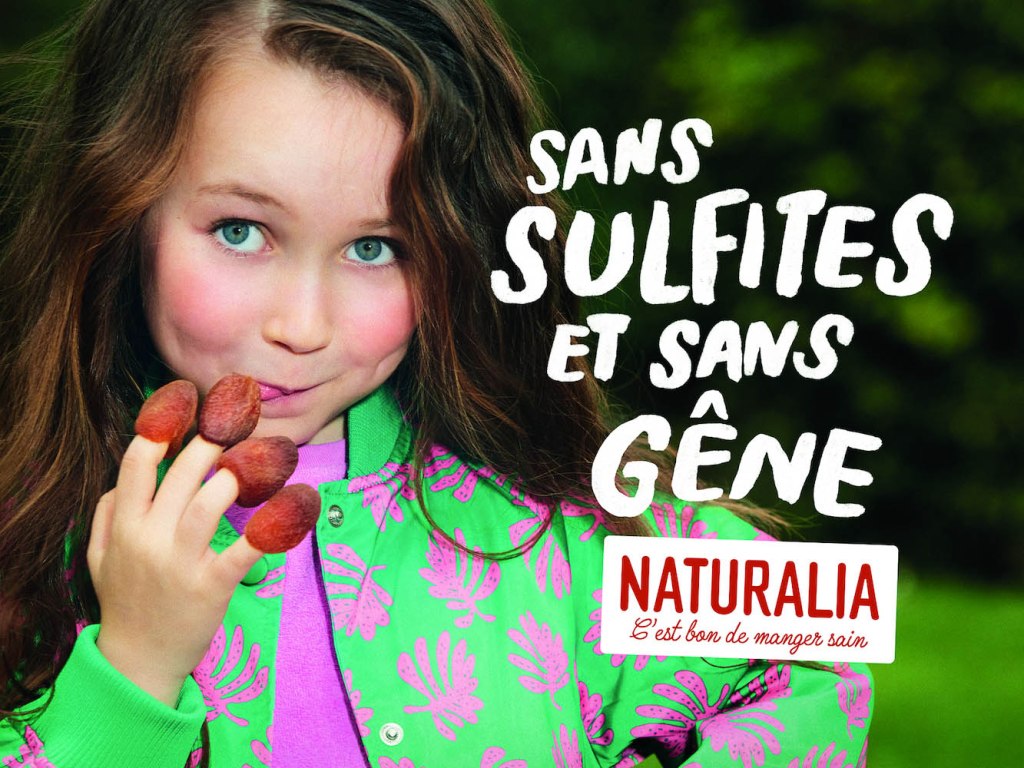Publicité Naturalia - C'est bon de manger sain - Agence Altmann+Pacreau - 2023 - Sans sulfites et sans gêne - Fillette avec framboises au bout des doigts