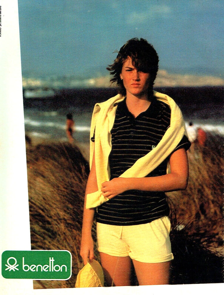 Publicité Benetton - Jeune femme femme en short et polo, avec pull clair sur les épaules - plage - 1981