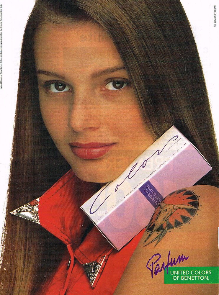 Publicité Benetton - Parfum - Colors - Portrait gros plan jeune femme brune avec packaging du parfum sur l'épaule sur laquelle se trouve un tatouage - Oliviero Toscani - 1993