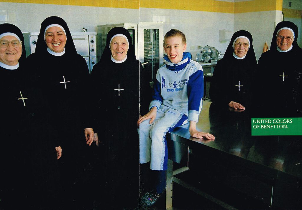 Publicité Benetton - Enfant en survêtement souriant au milieu de plusieurs religieuses - La Fabrica - Oliviero Toscani - 1998