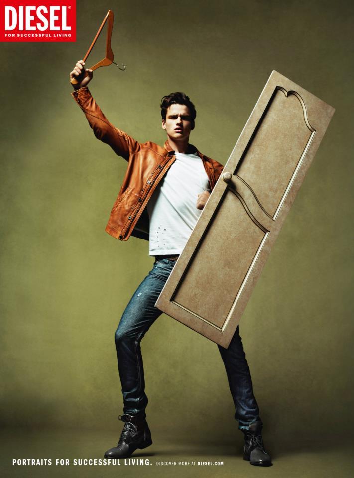 Publicité Diesel - Portraits for a successfull living - 2012 - Jeune homme avec cintre en guise d'arme et un porte de placard pour bouclier