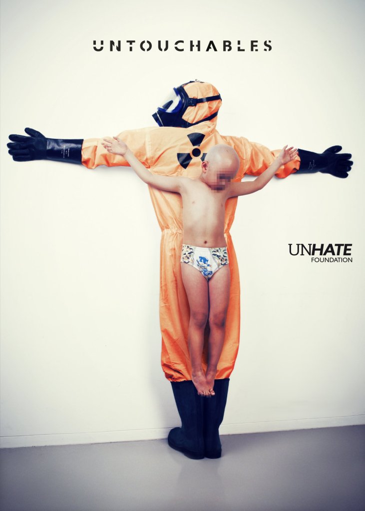Publicité Benetton - Untouchables - Unhate Foundation - La Fabrica - 2014 - Enfant crucifié dans le dos d'un homme avec une tenue contre les risques chimiques - Pollution