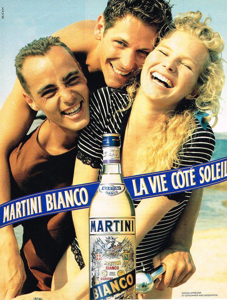 Publicité Martini - Martini Bianco la vie côté soleil - 2 hommes, une femme sur une plage - Plan serré Agence Mc Cann - 1990