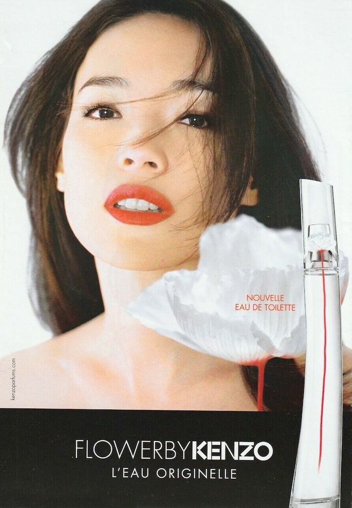 Publicité Kenzo - Flower by Kenzo - L'eau originelle - Femme en gros plan avec coquelicot géant blanc – packaging blanc avec tige rouge