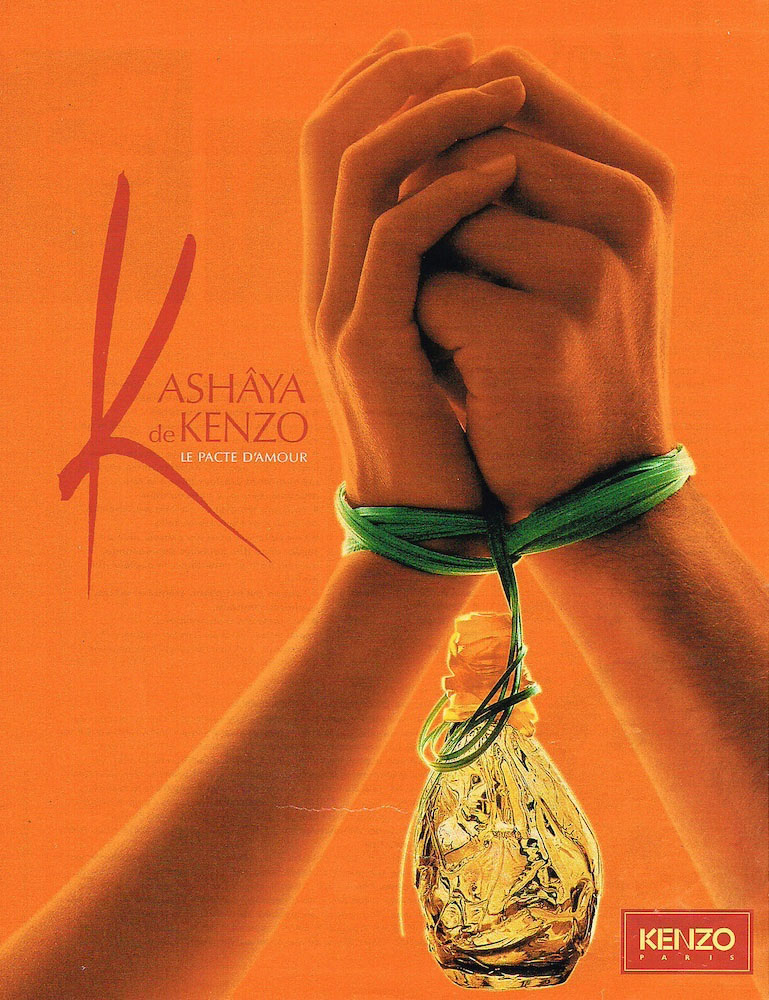Publicité Kenzo - Parfum Kashâya de Kenzo - Deux mains liées sur fond orange, la bouteille est suspendue aux liens - 1995 - Page simple
