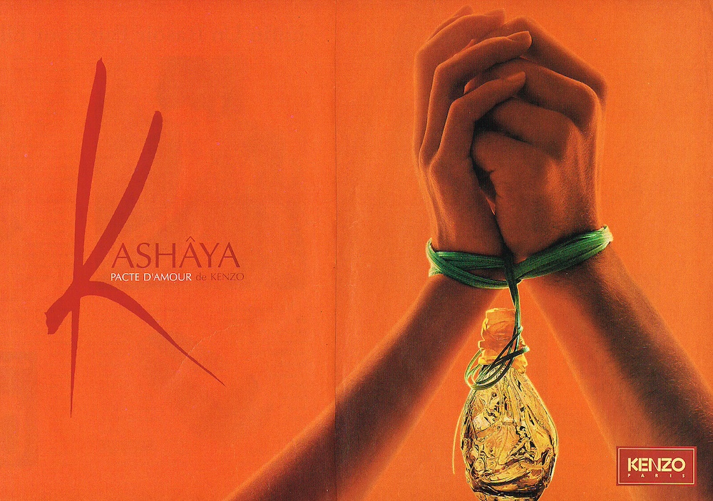 Publicité Kenzo - Parfum Kashâya de Kenzo - Deux mains liées sur fond orange, la bouteille est suspendue aux liens - 1995 - Page double