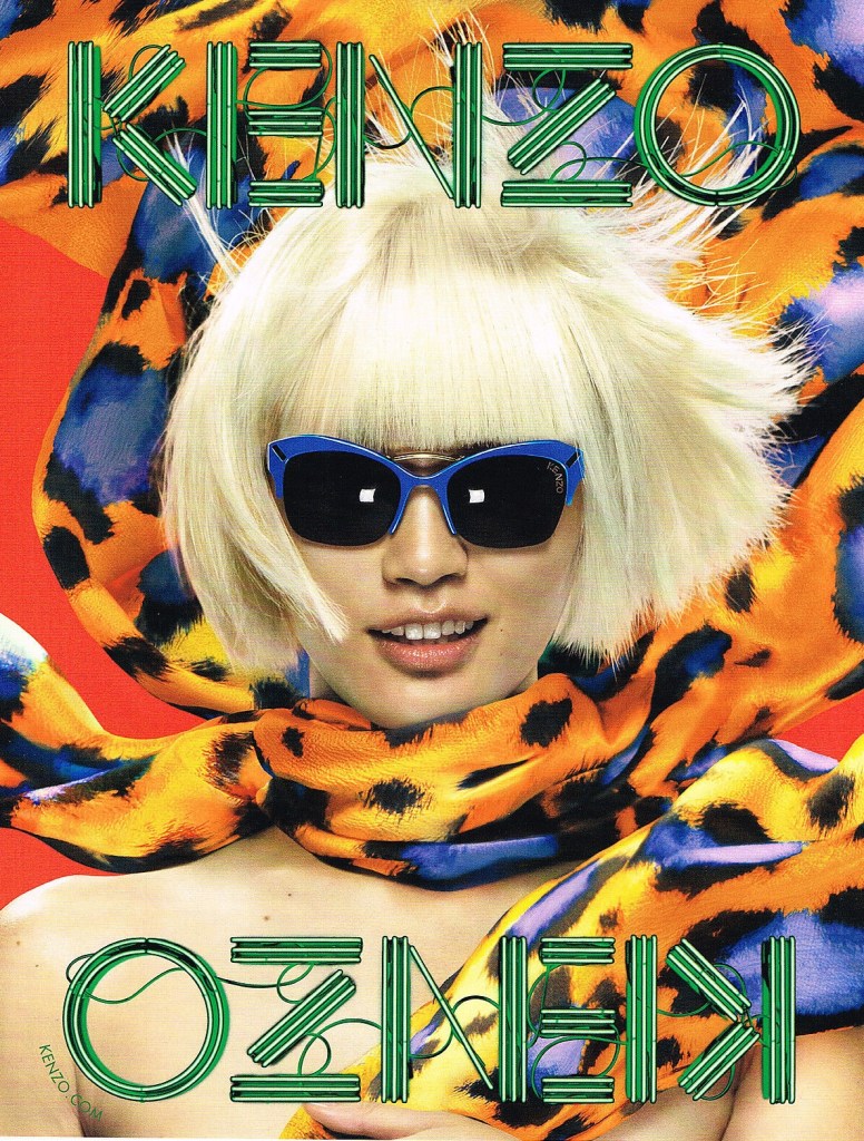 Publicité Kenzo - Lunettes - Femme blonde avec lunettes bleues entourée d'un foulard chatoyant - 2013
