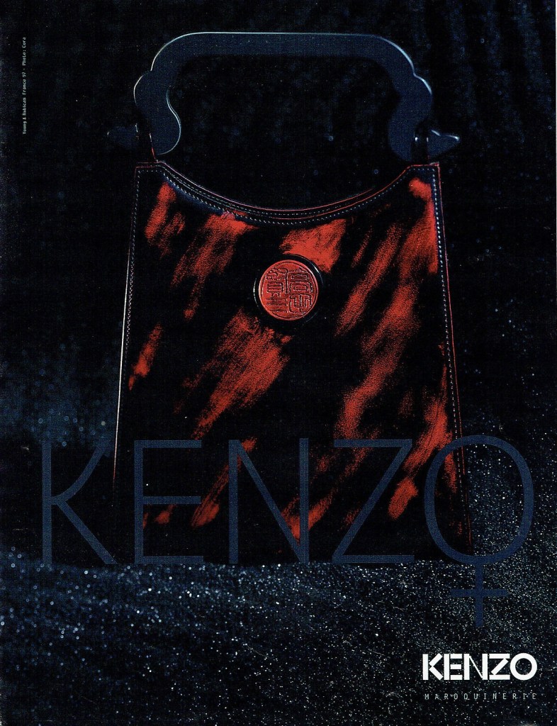 Publicité Kenzo - Sac - Sac noir et rouge sur un sol en sable noir - 1997