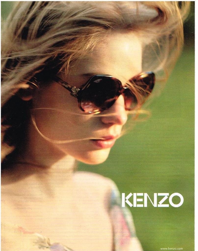 Publicité Kenzo - Lunettes - Femme blonde avec lunettes de soleil regarde en bas sur un fond nature - 2009