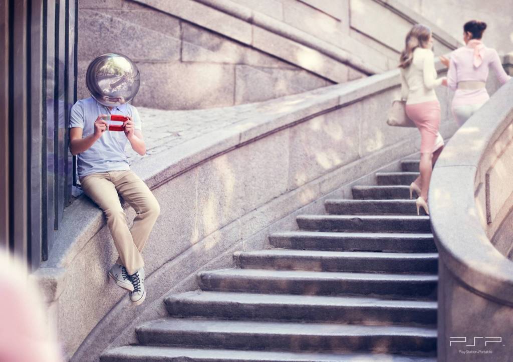 Publicité Playstation - PSP - Un homme assis sur le bord d'un escalier avec en guise de tête une boule métallique joue à la PSP présentée comme un aimant - Agence TBWA - Espagne - 2013