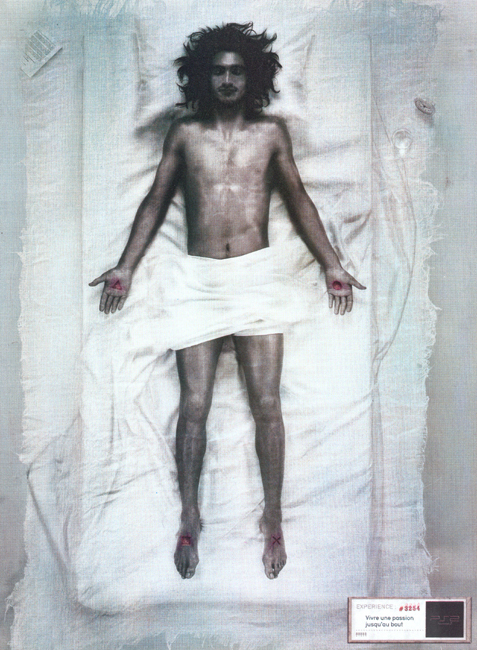 Publicité Playstation - PS2 - Expériences - N°3254 - Vivre jusqu'au bout une passion - Référence Jésus Christ - Pictogrammes de la marque sur les les mains et les pieds - TBWA Paris - 2003