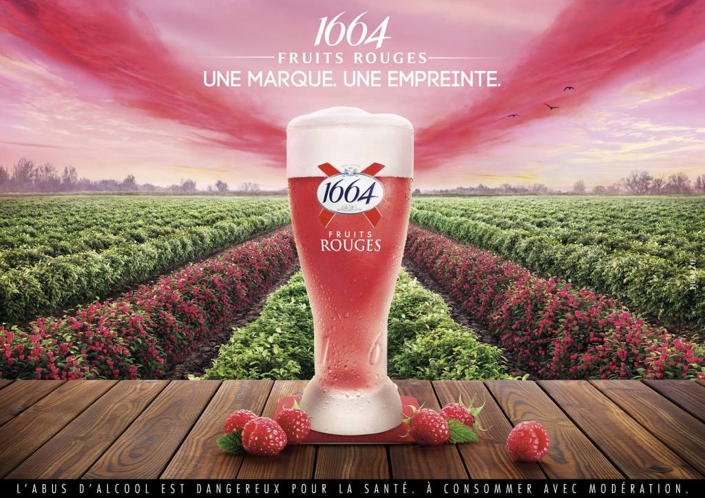 Publicité 1664 - Une marque, une empreinte - Fruits rouges - Verre au centre à côté de plusieurs framboises - Des halos roses dans le ciel et des rangées de framboisiers forment un X - Agence Hérézie - France - 2016