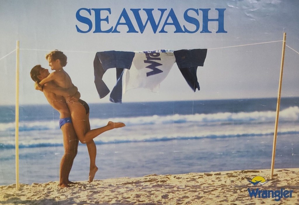 Publicité Wrangler - Seawash - Une femme et un homme s'enlace sur une plage près d'un fil à linge où leurs jeans sèchent - USA - 1980
