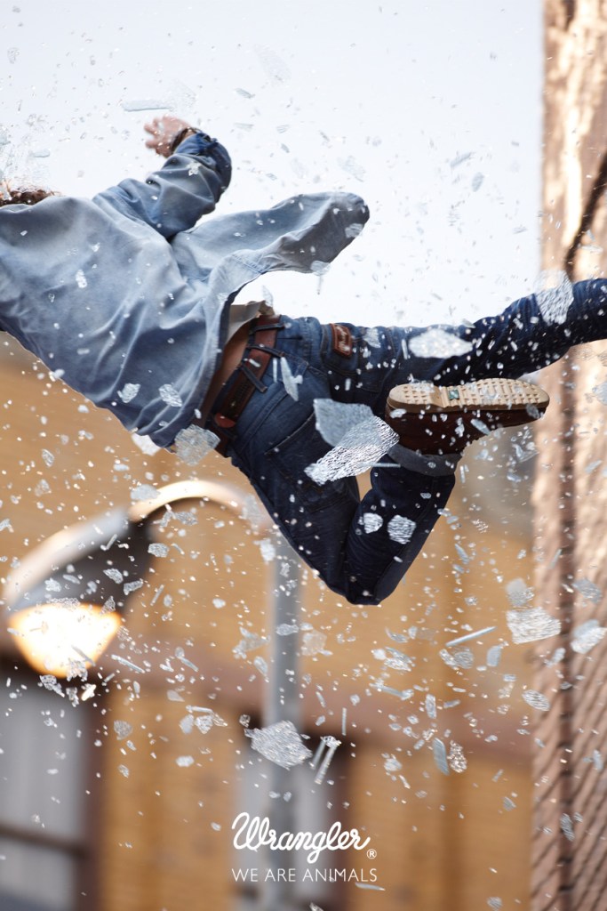 Publicité Wrangler - We are animals - Stunt - Un homme en chemise bleu clair tombe après avoir traversé la fenêtre - Agence Fred&Farid - France - Photographe Cass Berd
