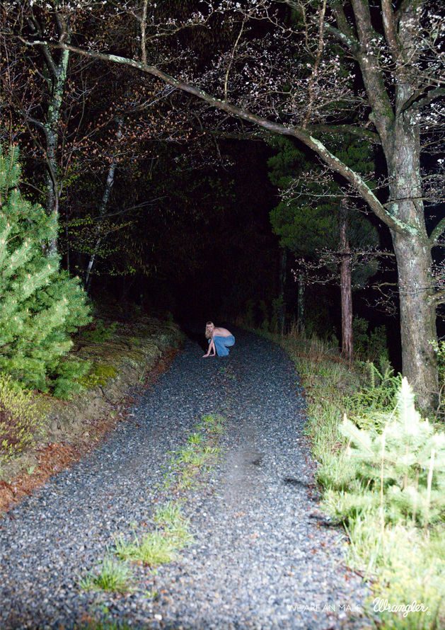 Publicité Wrangler - We are animals - Animals - Des phares éclairent une jeune femme accroupie au milieu d'un chemin - Agence Fred&Farid - France - 2010 - Photographe Ryan Mc Ginley