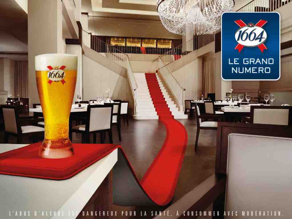 Publicité 1664 - Le grand numéro - Un verre de bière posé à la conclusion d'un tapis rouge - Décor de restaurant