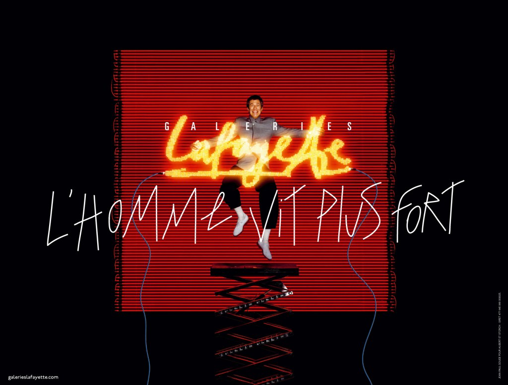 Publicité Galeries Lafayette - L'homme - L'homme vit plus fort - Jean Paul Goude en suspension devant un néon "Lafayette" - Agence Aubert Storch associés - Jean Paul Goude