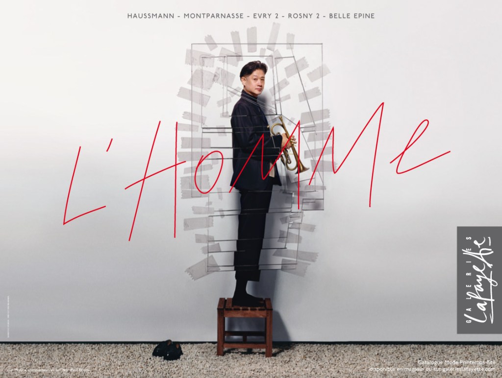 Publicité Galeries Lafayette - L'homme - Jun Miyake - Debout sur un tabouret, trompette à la main -Agence Aubert Storch associés - Jean Paul Goude - Collection Printemps-Été