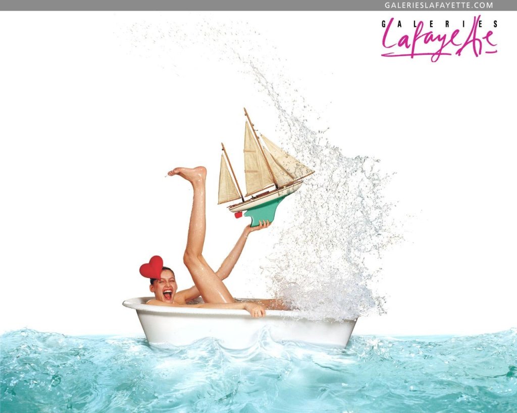 Publicité Galeries Lafayette - Bandeau gris - Laetitia Casta - Dans une baignoire au milieu de l'eau tient un bateau - Agence Aubert Storch associés - Jean Paul Goude