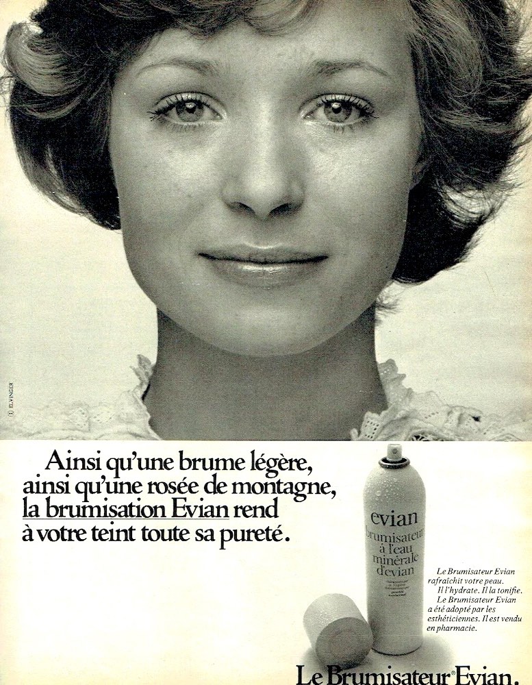 Publicité evian - Brumisateur - Ainsi qu'une brume légère, ainsi qu'une rosée de montagne, la brumisation evian rend à votre teint toute sa pureté - Gros plan sur le visage d'une femme - noir et blanc - 1972