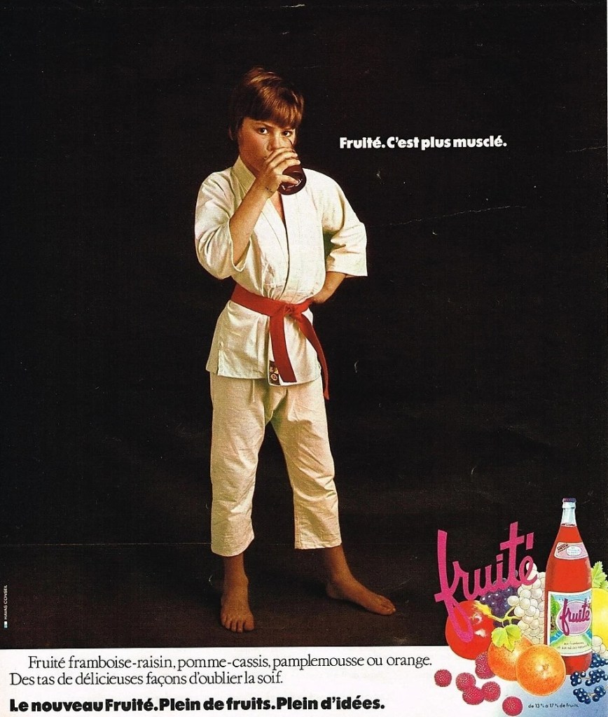 Publicité evian Fruité - Le nouveau Fruité. Plein de fruits. Plein d'idées - C'est plus musclé - Garçon habillé en judoka boit un verre de la boisson - 1974