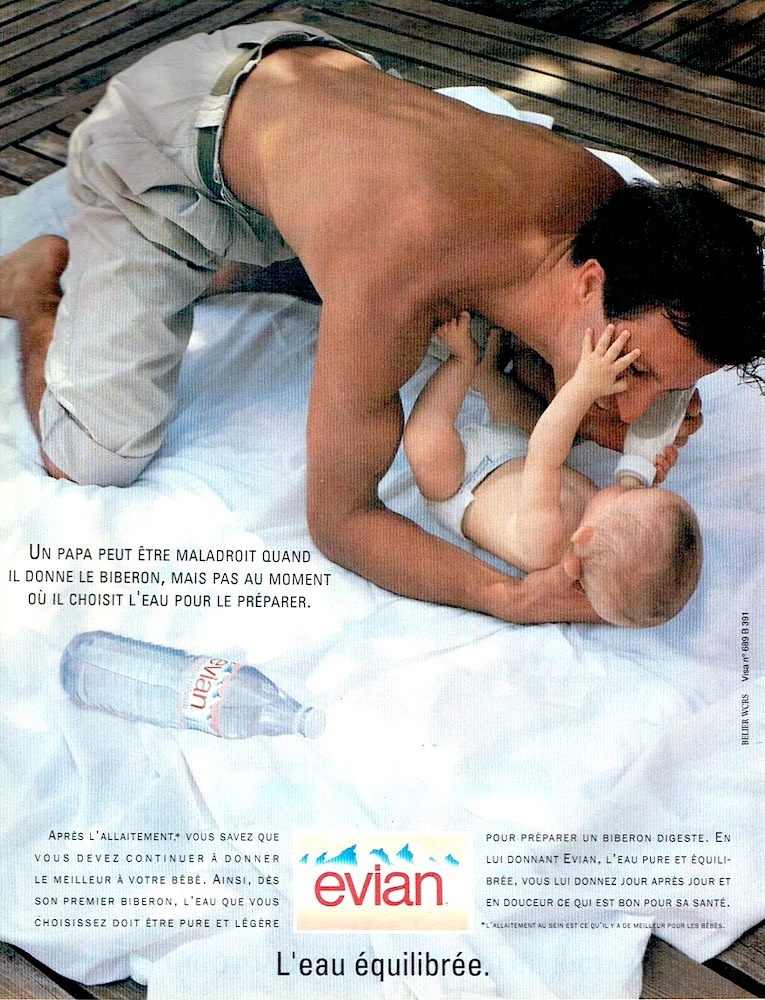Publicité evian - L'eau équilibrée - Père torse-nu penché sur son enfant pour lui donner le biberon - Agence Bélier WCRS - 1990