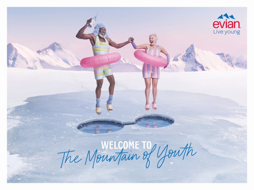 Publicité evian - Live Young - Welcome to the mountain of youth - Deux personnes âgées avec une bouée rose sautent à travers la glace pour se baigner - Agence BETC - 2024
