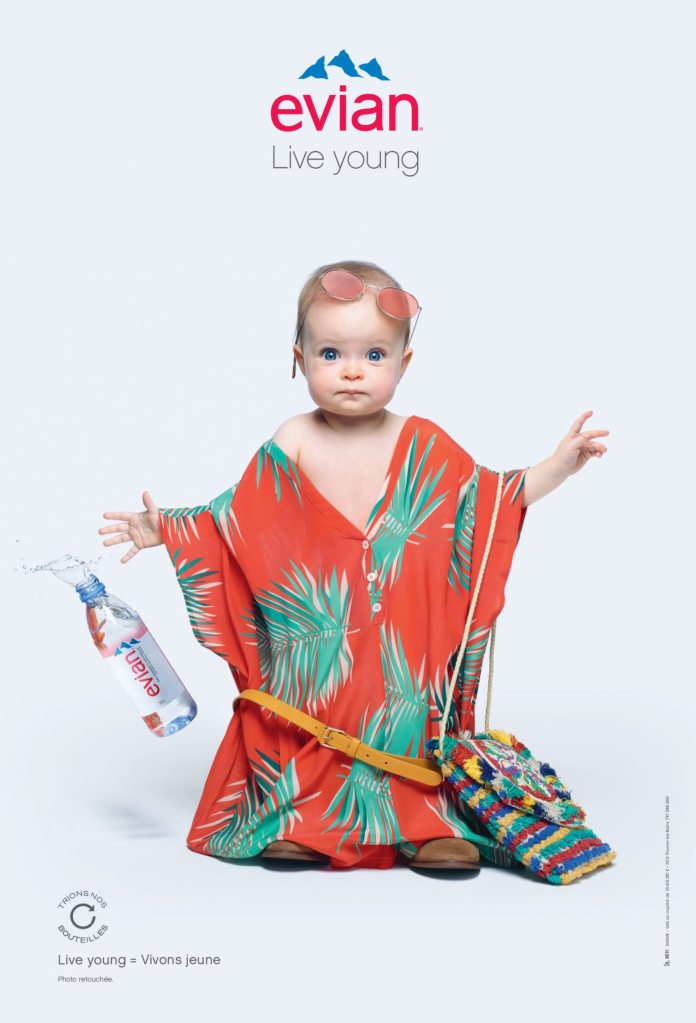 Publicité evian - Live Young - Oversize - Transformation - Enfant habillée avec une robe d'été et des lunettes - Vêtements trop grands - Agence BETC Paris - 2017