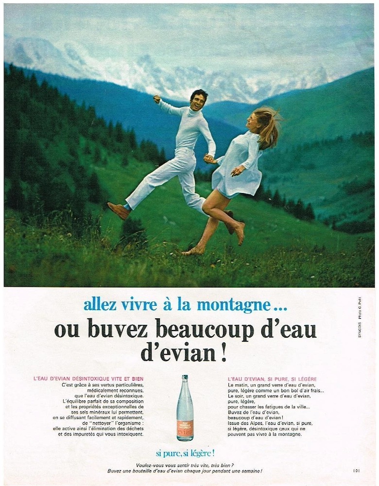 Publicité evian - Allez vivre à la montagne !.. ou buvez beaucoup d'eau d'evian - Couple en blanc fait un saut avec des montagnes dans le fond - 1970