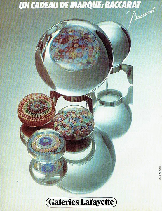 Publicité Galeries Lafayette - Un cadeau de marque Baccarat - Des objets en verre exposés sur un miroir - 1979