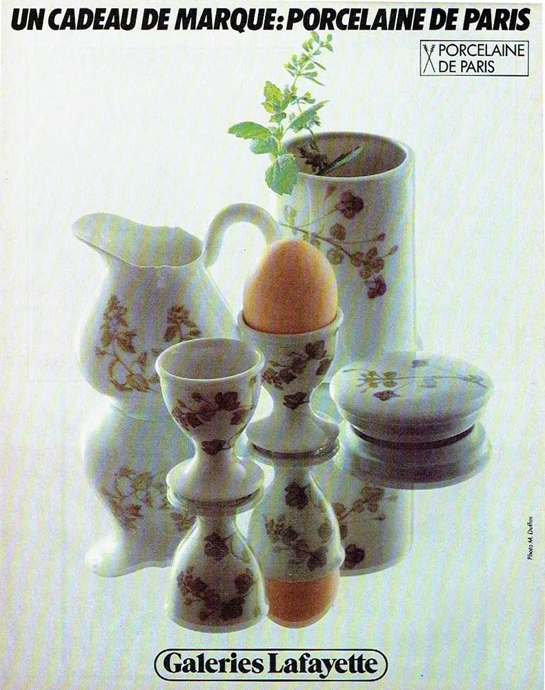 Publicité Galeries Lafayette - Un cadeau de marque porcelaine de Paris - Des porcelaines exposées sur un miroir - 1979