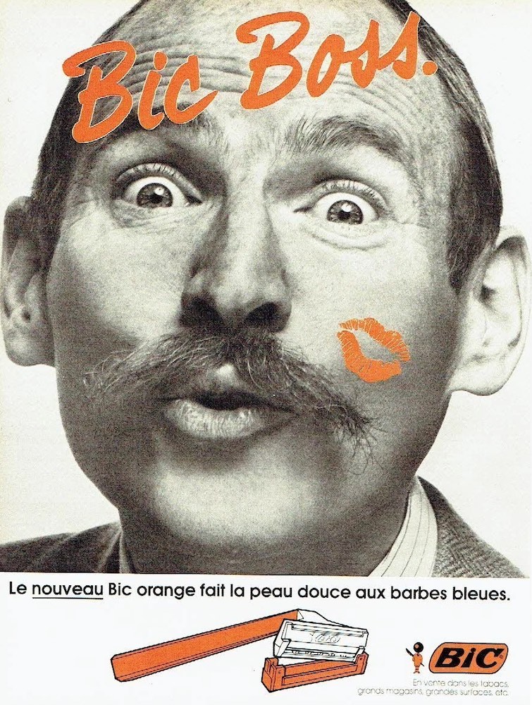 Publicité Bic - Nouveau Bic orange - Rasoir - Le nouveau Bic Orange fait la peau douce aux barbes bleues - Bic Boss - Homme moustachu avec un baiser orange dessiné sur la joue - Agence Futurs - 1981