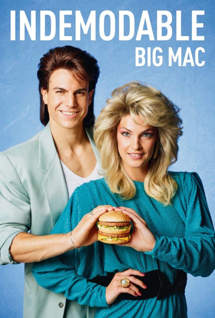 Publicité McDonald's - 50 ans Big Mac - Années 80 - Couple avec épaulettes carrés tiennent un Big Mac à deux - Agence TBWA Paris - 2018