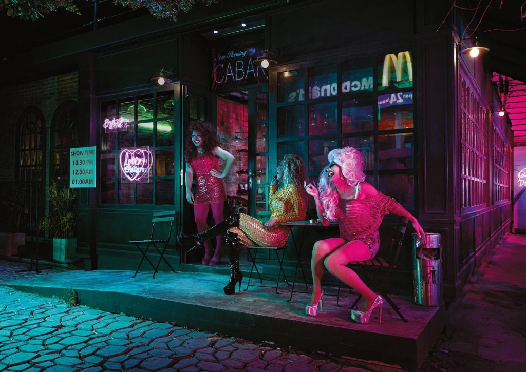 Publicité McDonald's - 24/24h - Reflets -  3 drag-queens à la terrasse d'un bar rigole la nuit - Le logo de la marque se reflète sur la vitrine duu bar - TBWA/DANThailand - Thaïlande - 2017