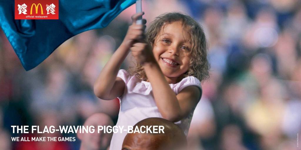 Publicité McDonald's - JO Londres - We all make the games - The Flag-Waving Piggy-Backer - Fillette debout dans la foule fait virevolter un drapeau - Agence Leo Burnett - UK - 2012