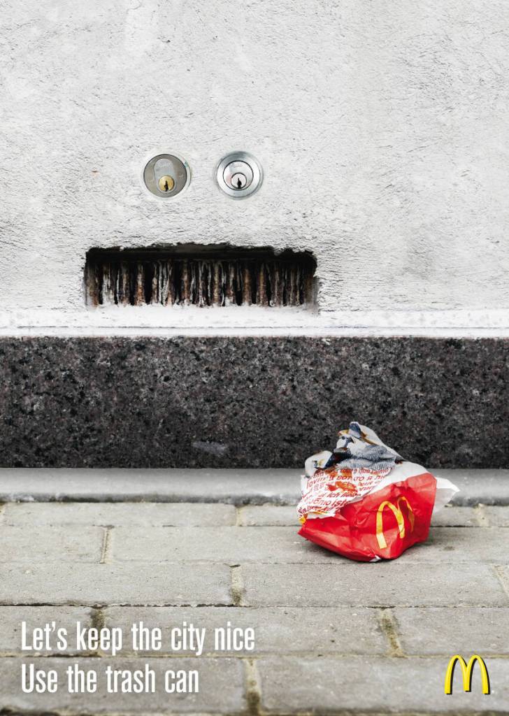Publicité McDonald's - Let's keep the city nice. Use the trash can - Un sac McDonald's vide jonche le sol  -  on perçoit sur le mur un visage qui exprime le mécontentement - Agence DDB - Danemark - 2008