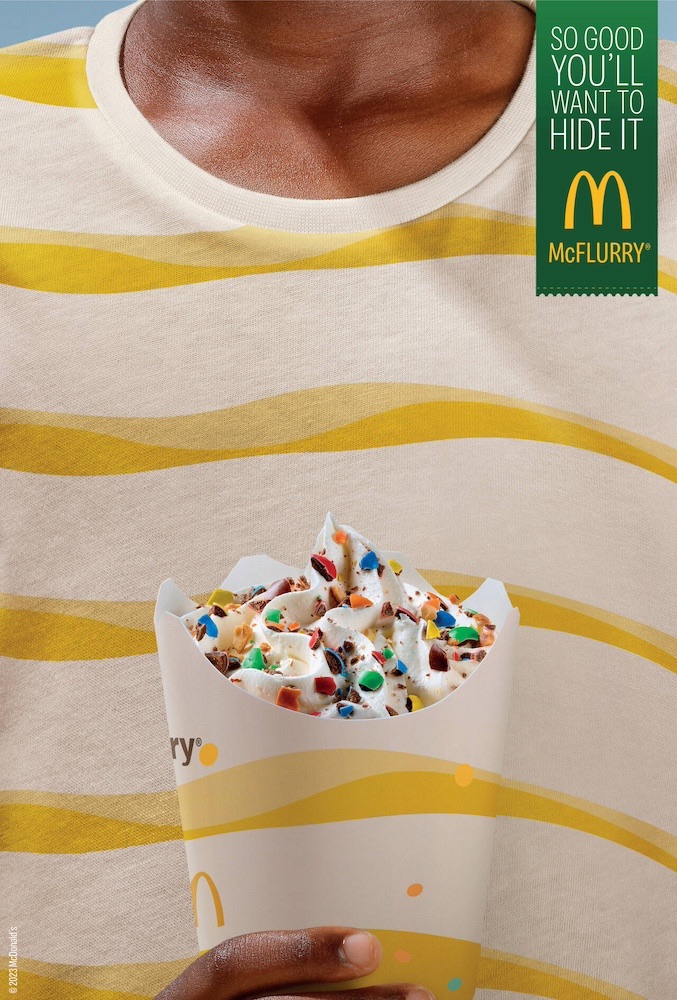 Publicité McDonald's - McFlurry - So good, you'll want to hide it - Le pot de McFlurry Smarties, de couleurs blanc et jaune se confond avec le tee-shirt - Agence TBWA - Portugal - 2023