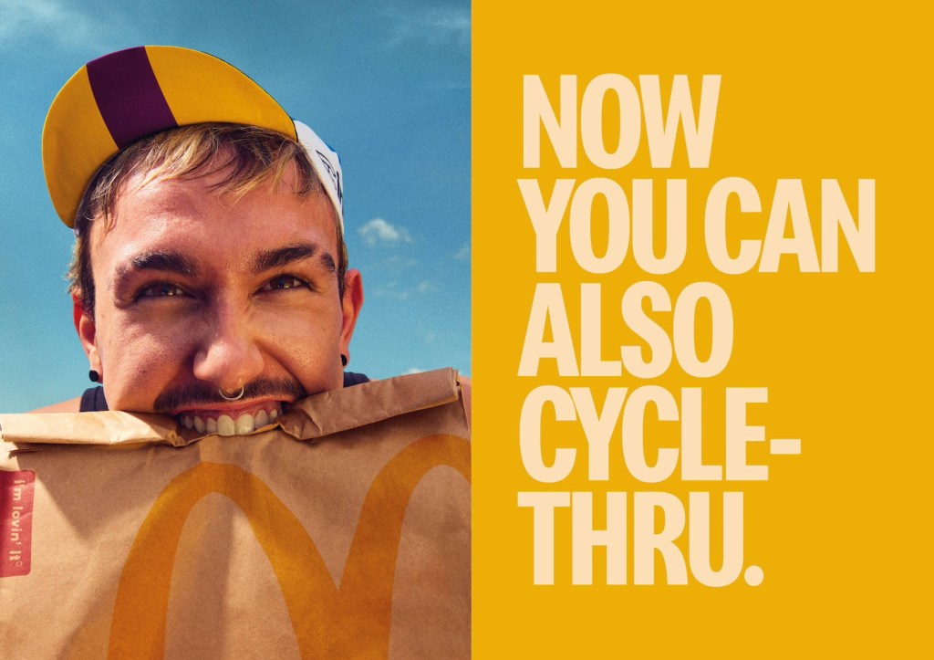 Publicité McDonald's - Drive - Now you can also cycle-thru - Jeune homme avec casquette et piercing dans le nez tient un sac dans sa bouche - Agence TBWA - Espagne - 2024