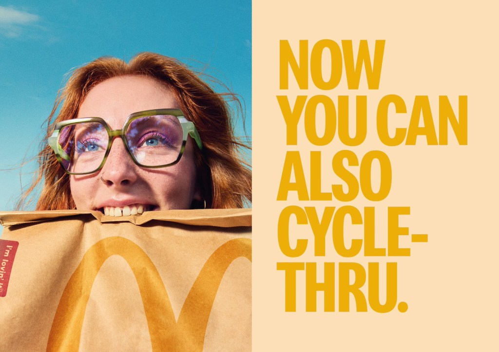 Publicité McDonald's - Drive - Now you can also cycle-thru - Jeune femme à lunettes tient un sac dans sa bouche - Agence TBWA - Espagne - 2024