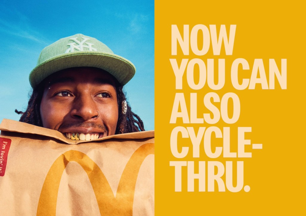 Publicité McDonald's - Drive - Now you can also cycle-thru - Jeune homme avec dents dorées, casquette verte et rasta tient un sac dans sa bouche - Agence TBWA - Espagne - 2024
